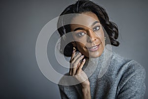 Portrait of an african american woman wearing grey sweater againsta isolated background