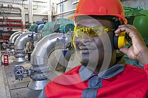Portrait Of African American Worker In Protective Workwear In Industrial Interior With Pipes And Generators