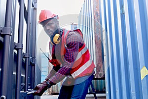 Portrait of African American young engineer worker man wearing safety bright neon red color vest and helmet, trying to open a