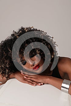 Portrait of African American young woman with afro hair posing indoor. Close-up.