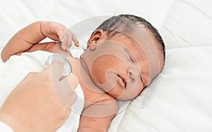 Portrait of african infant sleeping on bed