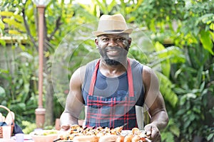 Portrait African man toasting and grill barbecue and barbecue ready for serve.