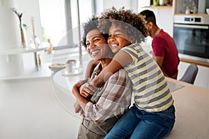 Portrait of african mother hugging with her daughter, enjoying moment of love, having fun together