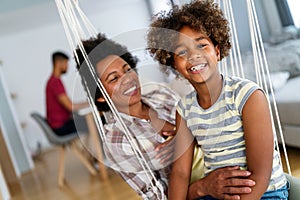 Portrait of african mother hugging with her daughter, enjoying moment of love, having fun together