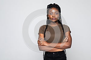 Portrait of african woman with arms folded standing over gray background