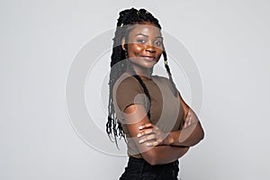 Portrait of african woman with arms folded standing over gray background