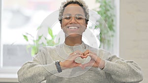 Portrait of African Woman showing Heart Shape by Hands