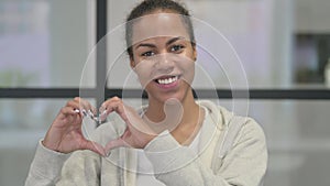 Portrait of African Woman showing Heart Shape by Hands