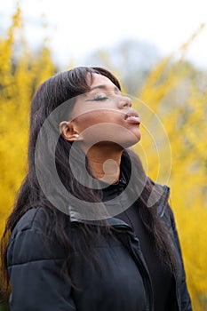 Portrait of an African woman who is relaxing in nature, yellow flowers in the background, breathing air