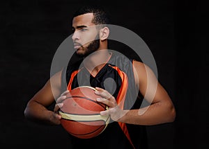Portrait of an Afro-American sportsman. Basketball player in sportswear with a ball