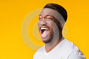 Portrait Of Afro Guy Laughing Out Loud Standing In Studio