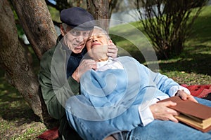 Portrait of aged couple enjoying lying on ground