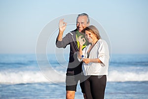 Portrait of aged couple spending freetime near sea