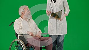 Portrait of aged man isolated on chroma key green screen background. Senior man in wheelchair talking with female doctor