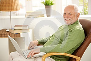 Portrait of aged man with laptop