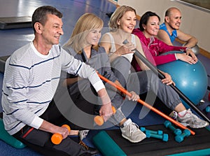 Portrait of aged men and women in top form in modern gym