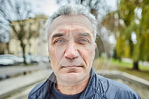 Portrait of aged serious man outdoors