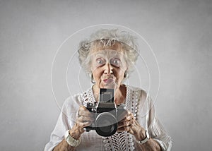 Portrait of an aged woman with a camera