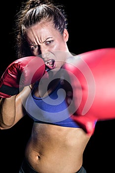 Portrait of aggressive female boxer with fighting stance