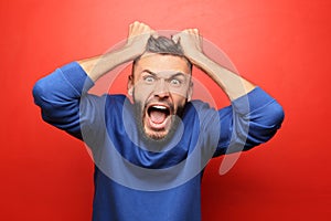 Portrait of aggressive man on color background