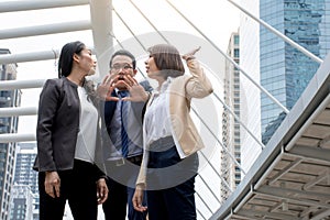 Portrait of Aggressive young Asian women in formal wear or businesswoman fighting while man dissuade for fight