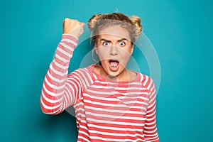 Portrait of aggressive young woman on color background