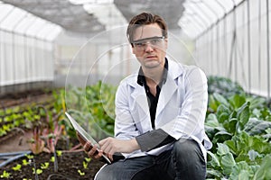 Portrait agriculture scientist man working plant research in bio farm laboratory.biologist study collecting data with laptop