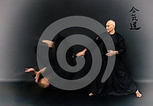 Portrait of aikido sensei master with black sensei belt in taekwondo kimono on black background. Traditional samurai hakama kimono