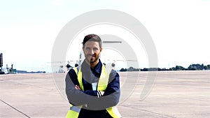 Portrait of aircraft marshaller standing with arms crossed