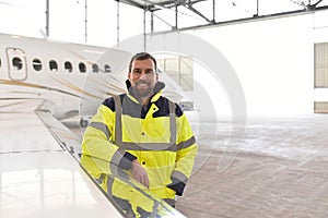 Portrait of an aircraft mechanic in a hangar with jets at the ai