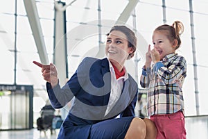 Portrait of airport staff playing with cute little girl in airport