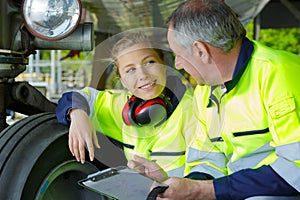 Portrait airport workers inspecting aircraft