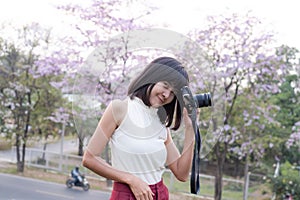 Portrait Alone Woman happy smile and holding Camera photography on blur flower