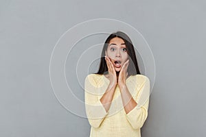 Portrait of amazed astonished young woman with opened mouth