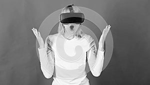 Portrait of an amazed girl using a virtual reality headset isolated on red background. Person with virtual reality