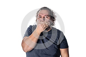 Portrait of amazed man covering his mouth over white background