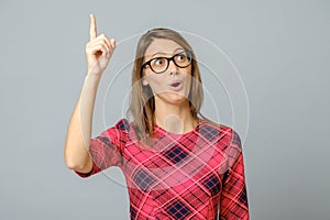 Portrait of amazed pretty woman pointing with finger with open mouth
