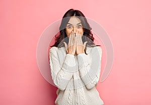 Portrait of amazed young woman over pink background