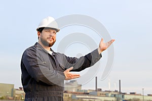 Portrait of american foreman with outstetched hands standing in construction site background.