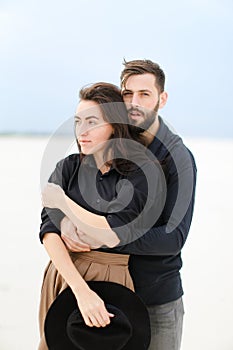 Portrait of american man hugging woman in monophonic background.