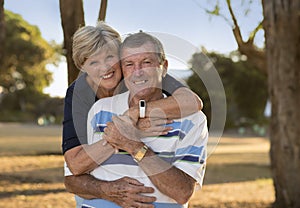 Portrait of American senior beautiful and happy mature couple around 70 years old showing love and affection smiling together in t