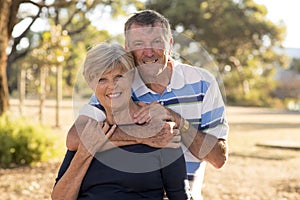 Portrait of American senior beautiful and happy mature couple around 70 years old showing love and affection smiling together in t