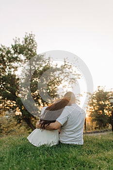 Portrait of amorous adorable cheerful couple spouses hugging sitting enjoying weekend fresh air outdoors. The concept of a happy