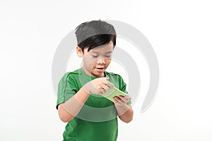 Portrait of an amused cute little kid playing games on smartphone isolated over white background