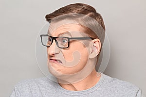 Portrait of angry annoyed mature man with glasses, grimacing from rage