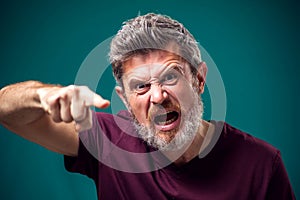 A portrait of angry bearded man pointing finger at camera. People and emotions concept