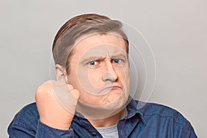 Portrait of angry disgruntled man shaking fist in threatening gesture