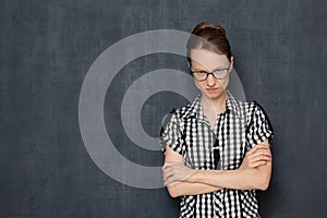 Portrait of angry enraged girl with glasses, crossing arms over body