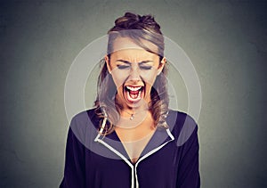 Portrait of an angry frustrated young woman screaming