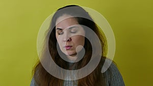 Portrait of an angry and indignant woman on a yellow background.